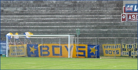 Alcuni tricolori blu-bianco-gialli sventolano dietro gli striscioni BOYS appesi in Curva: 'Curva Nord Matteo Bagnaresi', 'BOYS', 'Diffidati BOYS' e 'Tino con noi'